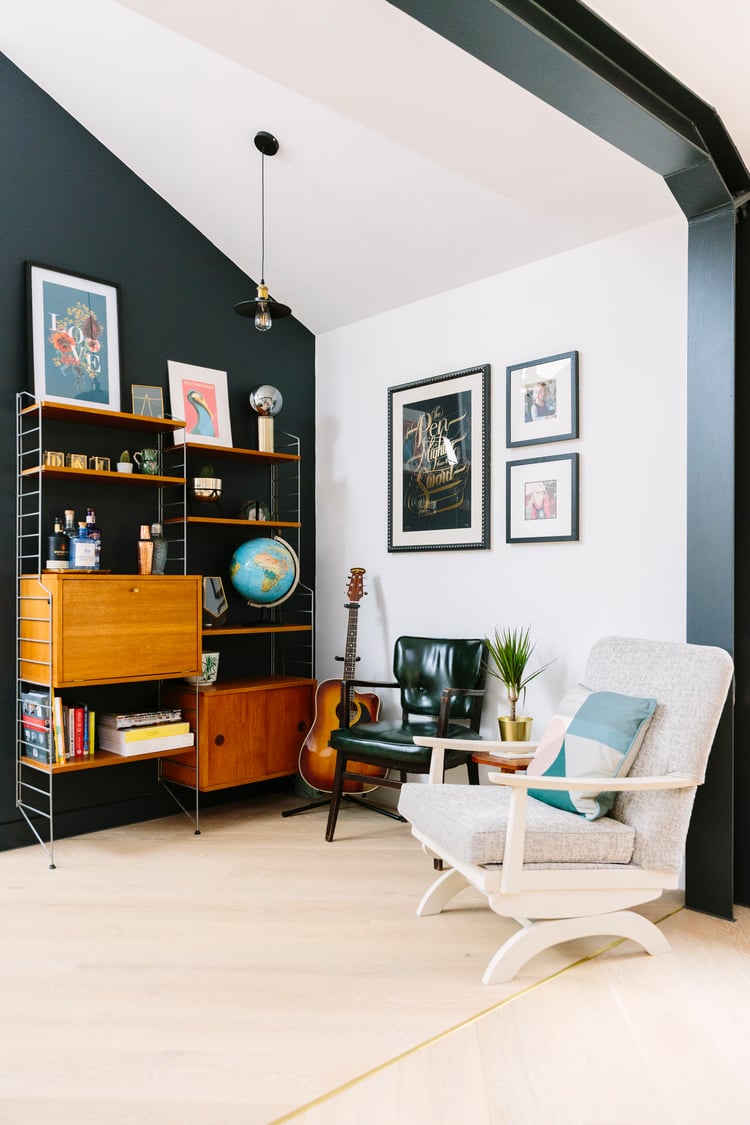 eclectic mid-century modern living space with open shelving and gallery wall 