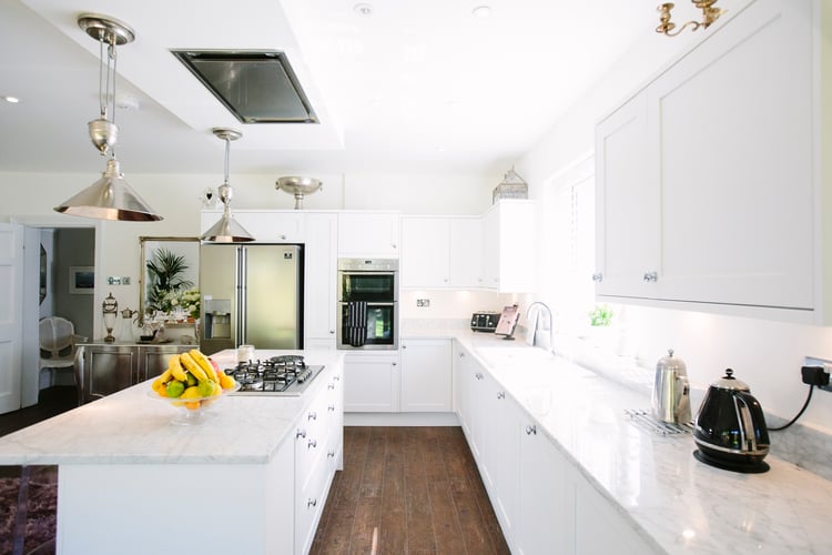 bright white marble kitchen design with pendants over island 