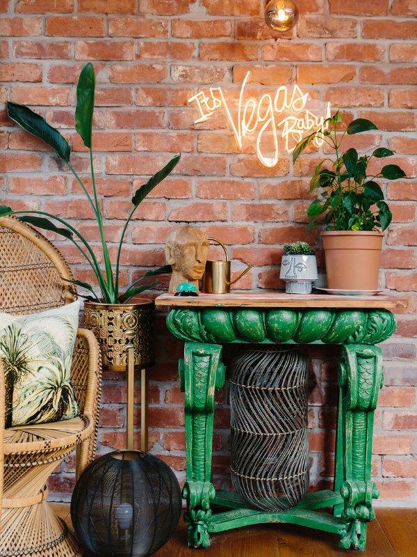 plants with green table and exposed brick wall