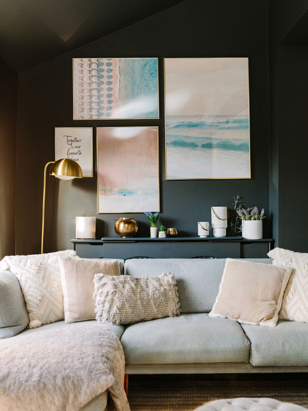 Black wall with pastel art and sofa