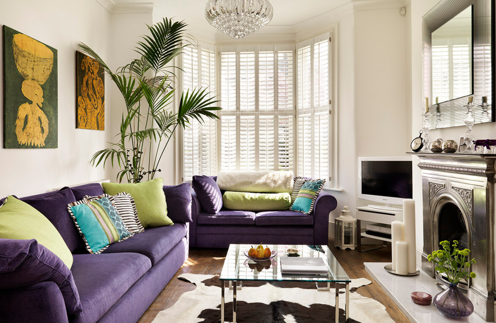 living room with purple sofas and cow print rug