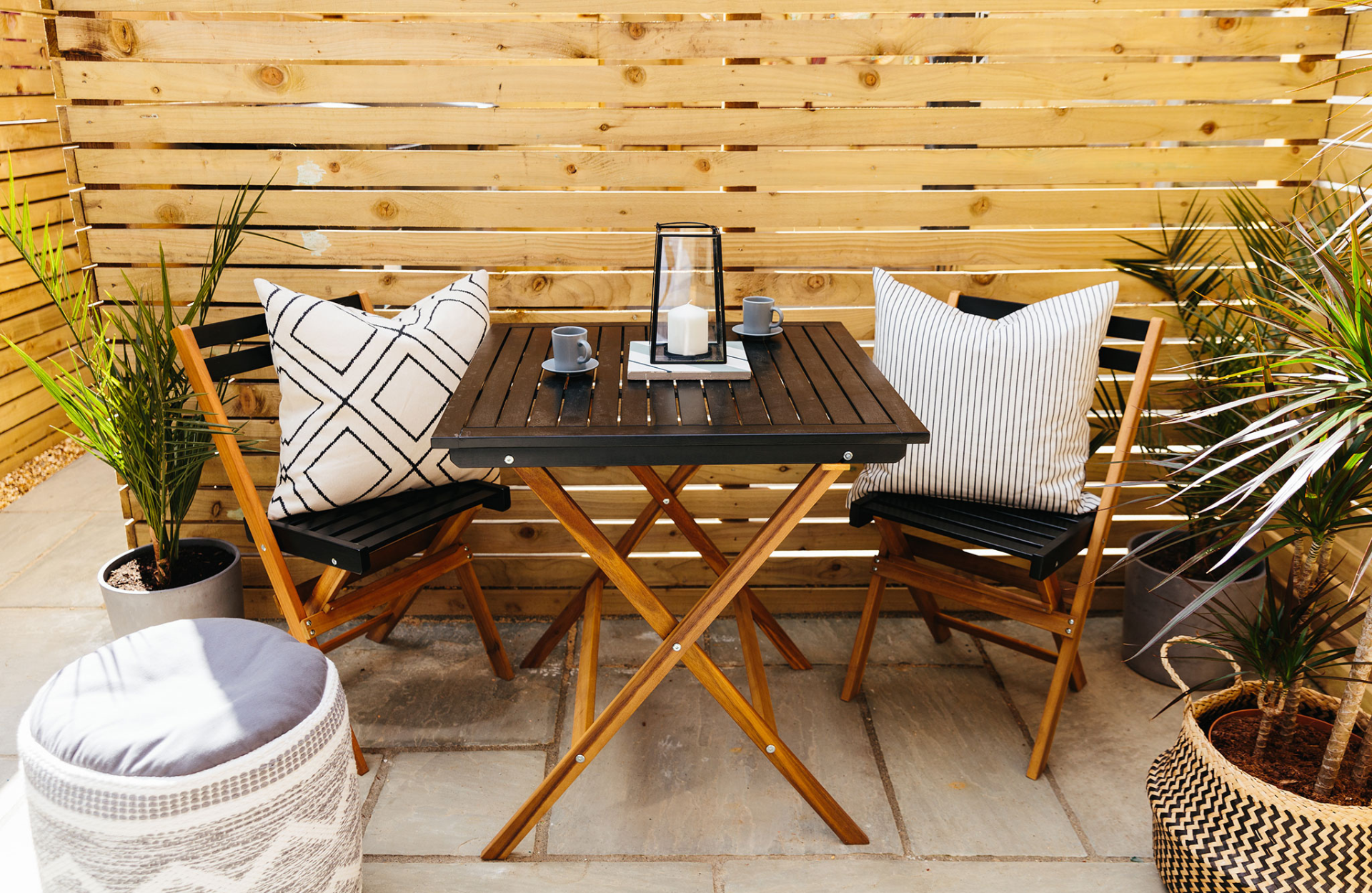 outdoor chairs and table with lamp and pillows