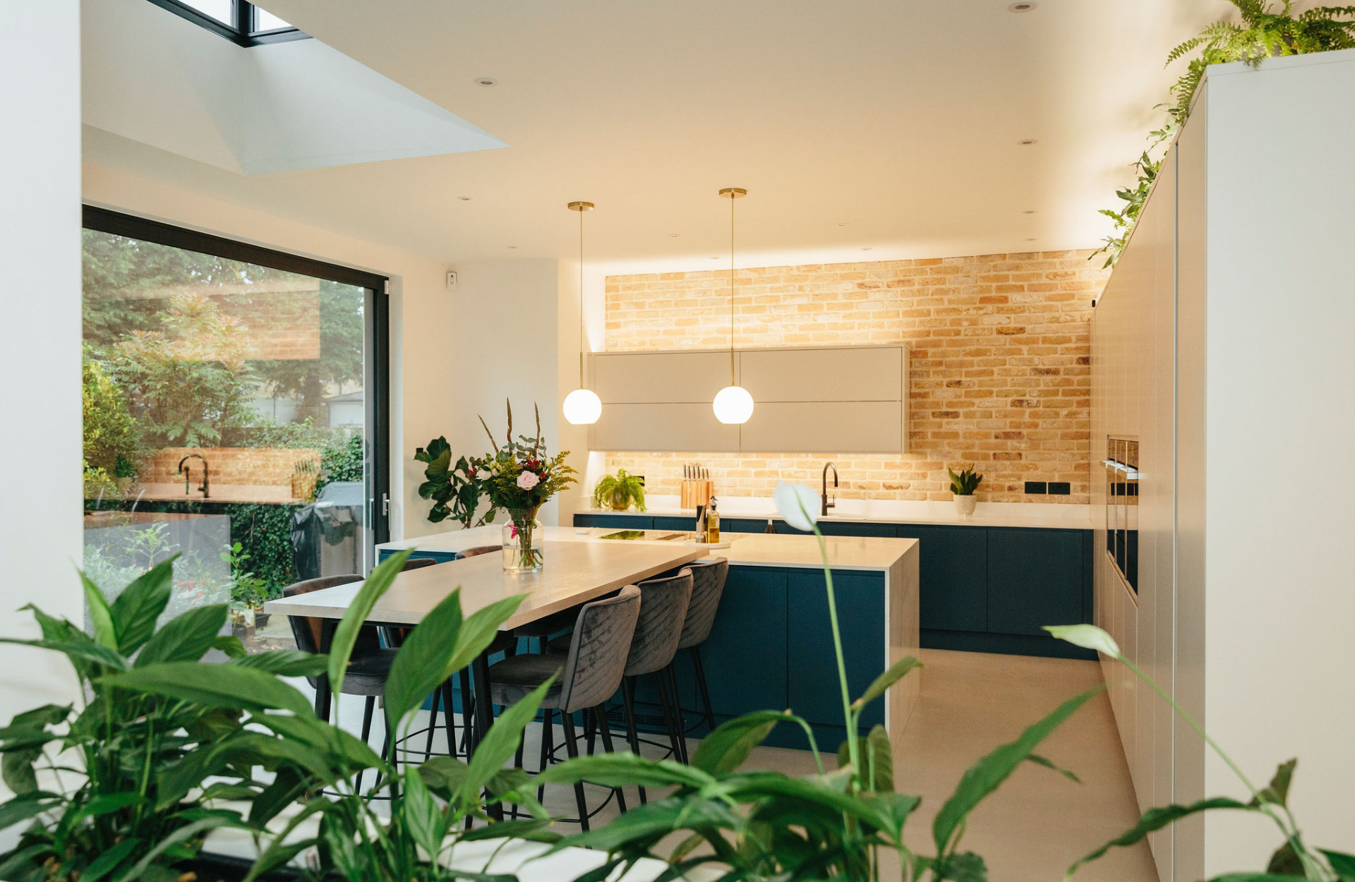 blue kitchen and brick feature wall