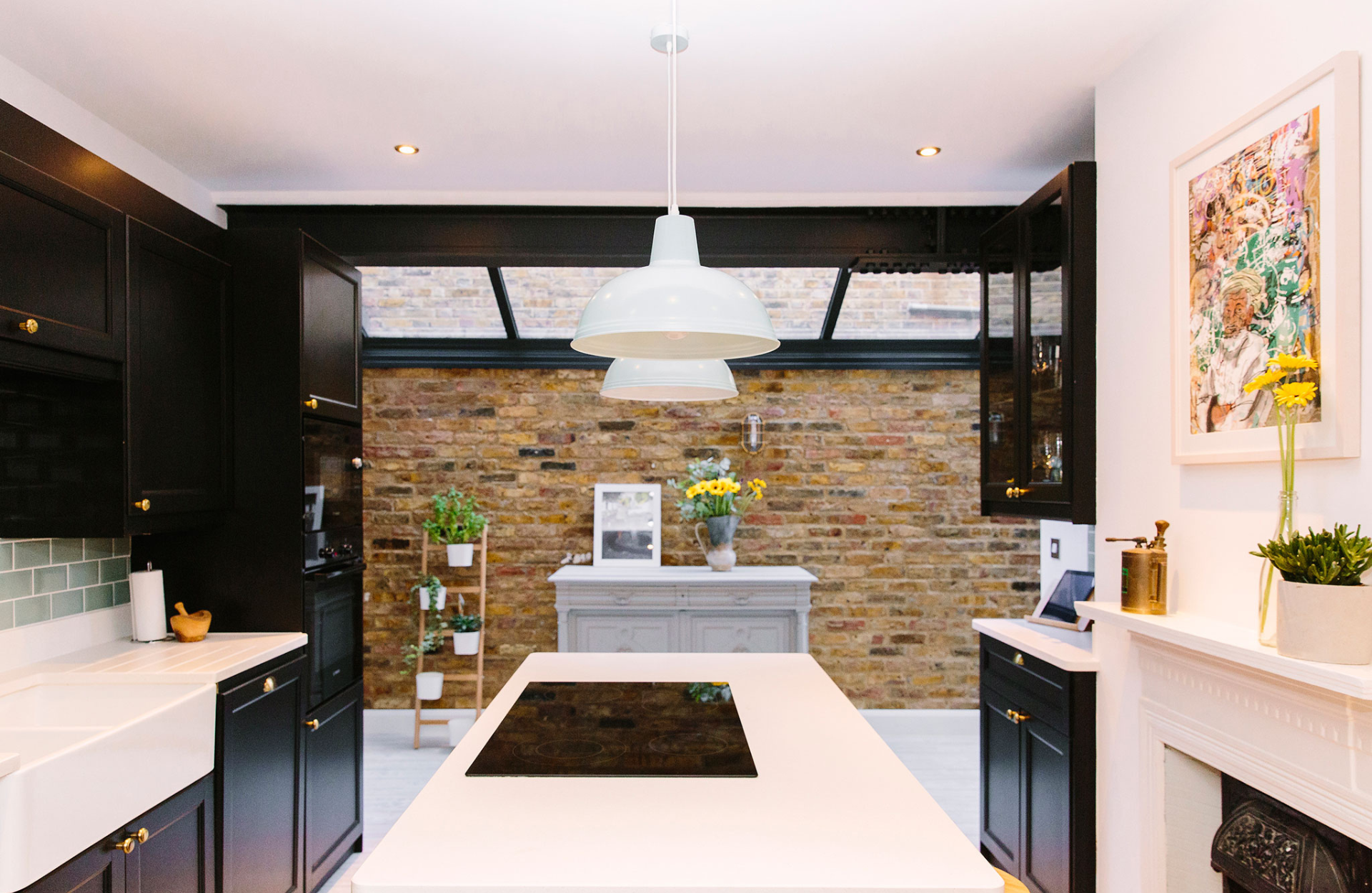 Black kitchen with brick extension