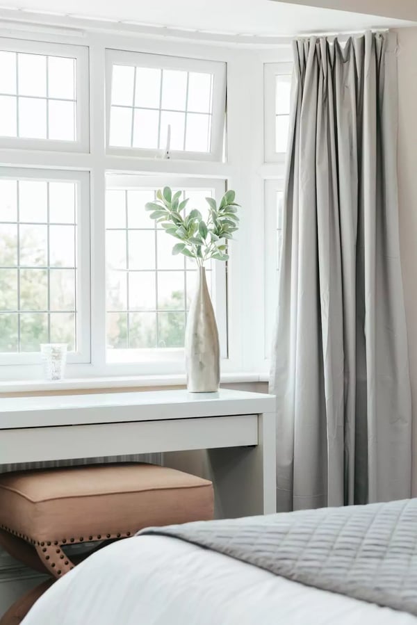 Bedroom window letting in the natural light causing positive mental health benefits