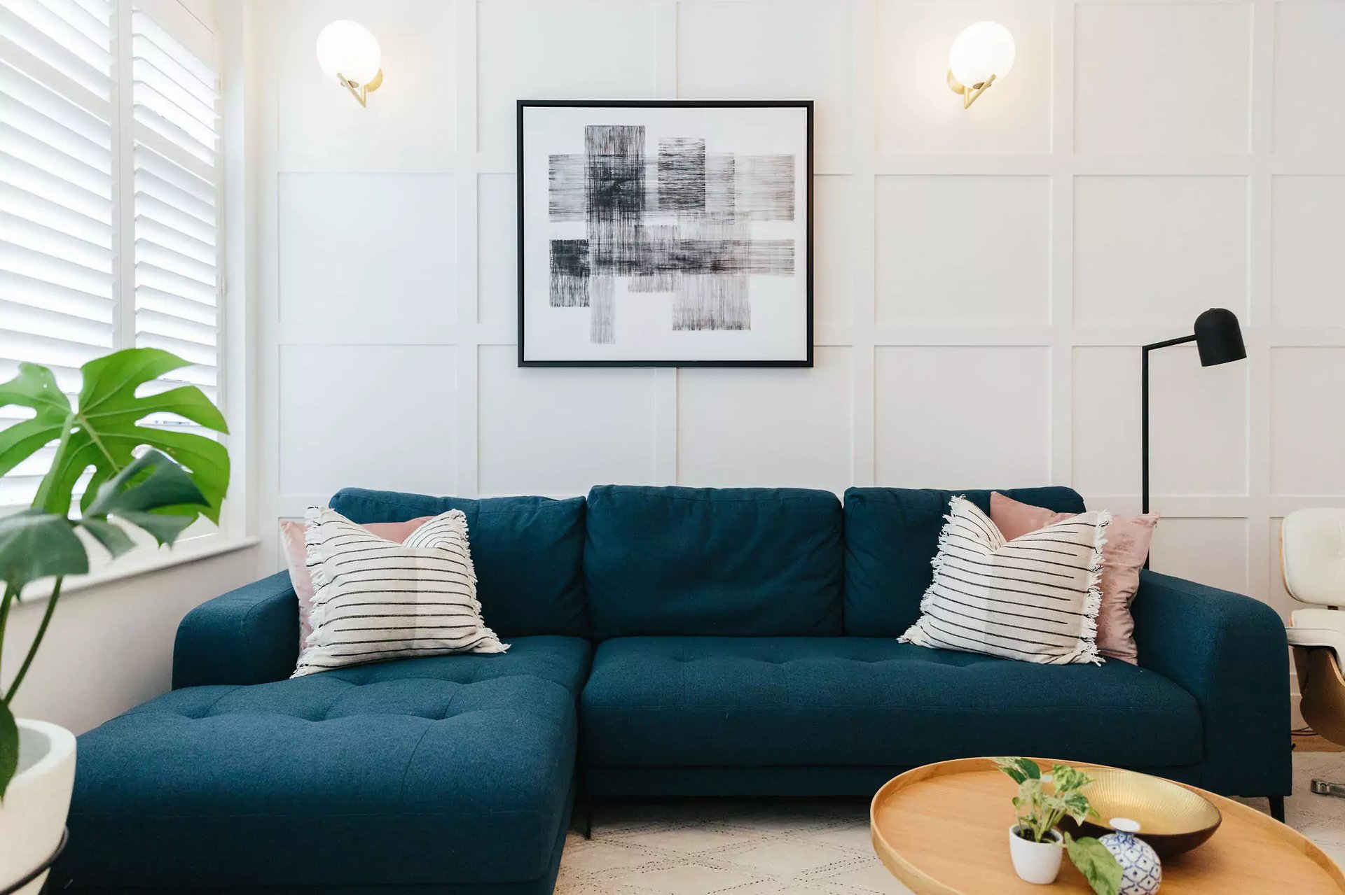 Bright paneled living room with dark blue sofa | online interior design